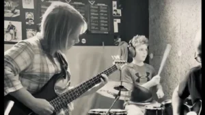 Madre e hijo tocando Back in Black juntos en una clase de Batería