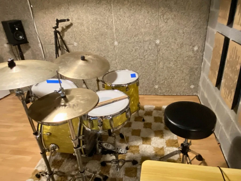 Zona de batería con platos y asiento en la sala de práctica
